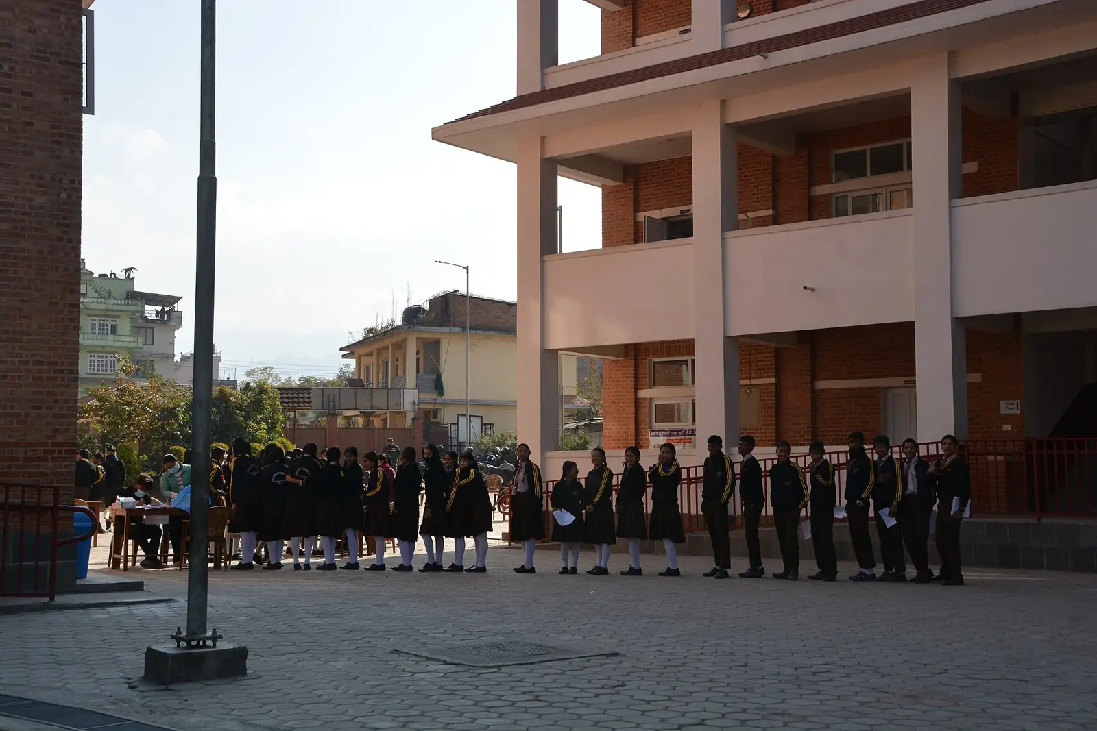 Students in school uniform queue in the schoolyard of Shree Bhagawati Secondary School, Sankhu, Kathmandu, in December 2024