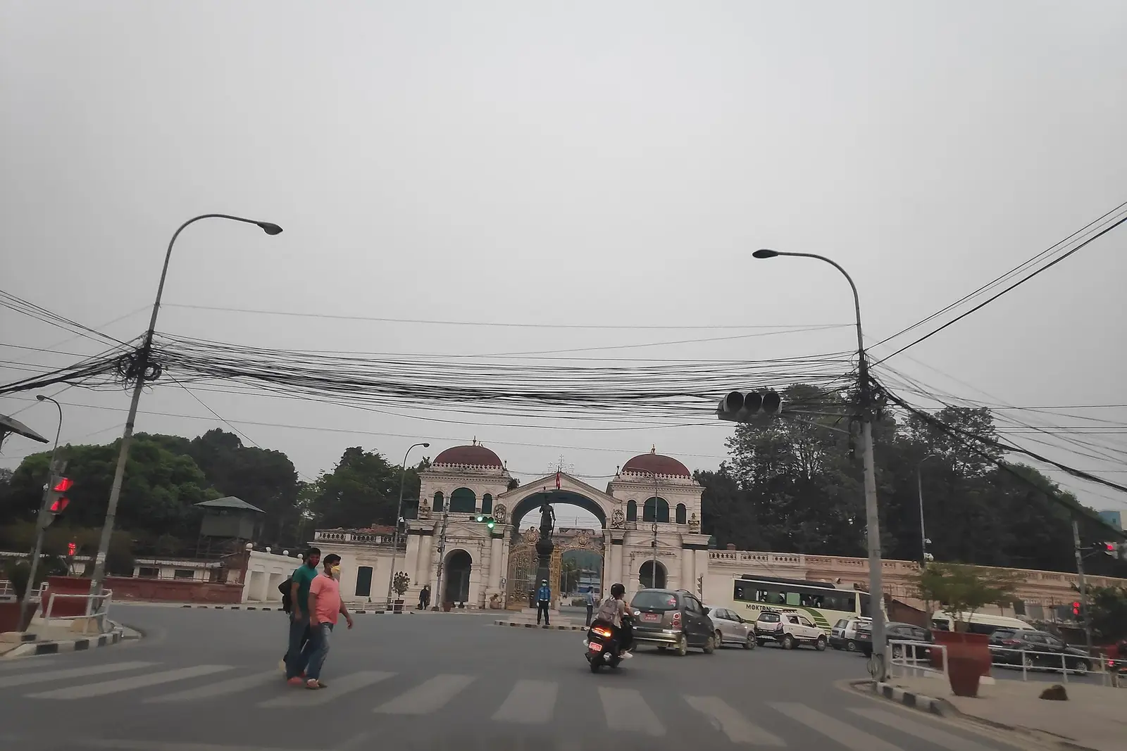 The main gate of Singha Durbar, the government secretariat in Kathmandu, with traffic and pedestrians in front